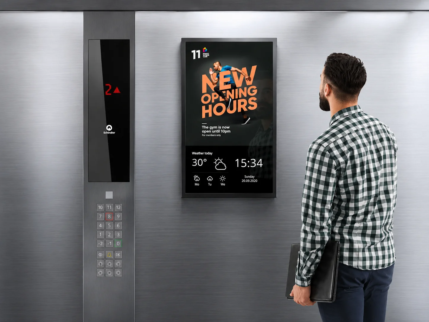 Slim-profile digital screen mounted inside an elevator cabin showing promotional content